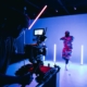 Das Thumbnail unseres Videoproduktion Anbieter Vergleichs zeigt einen Kameramann, der vor einem blauen Hintergrund ein Video aufnimmt.