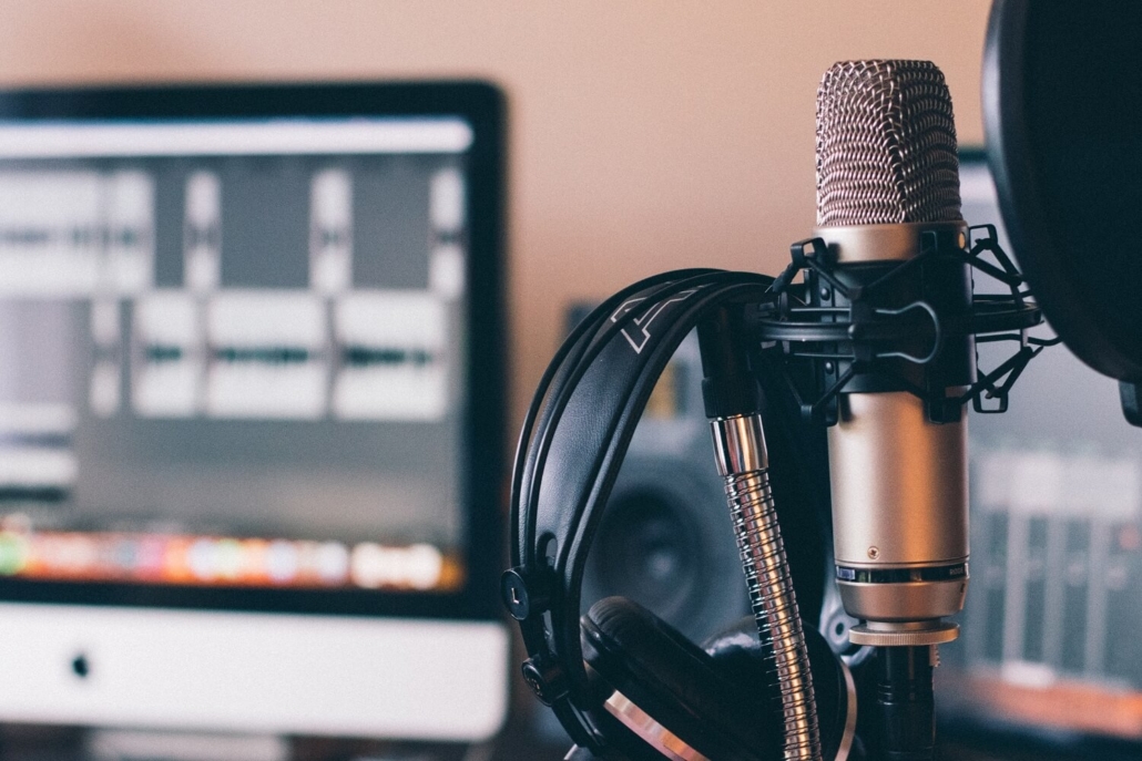 Ein Kopfhörer und ein Mikrofon wurden an einen Computer angeschlossen, um einen Podcast zu erstellen.