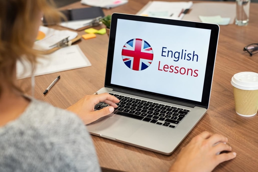 Eine Frau schaut sich auf Ihrem Laptop ein Lernvideo an, um ihr Englisch zu verbessern.