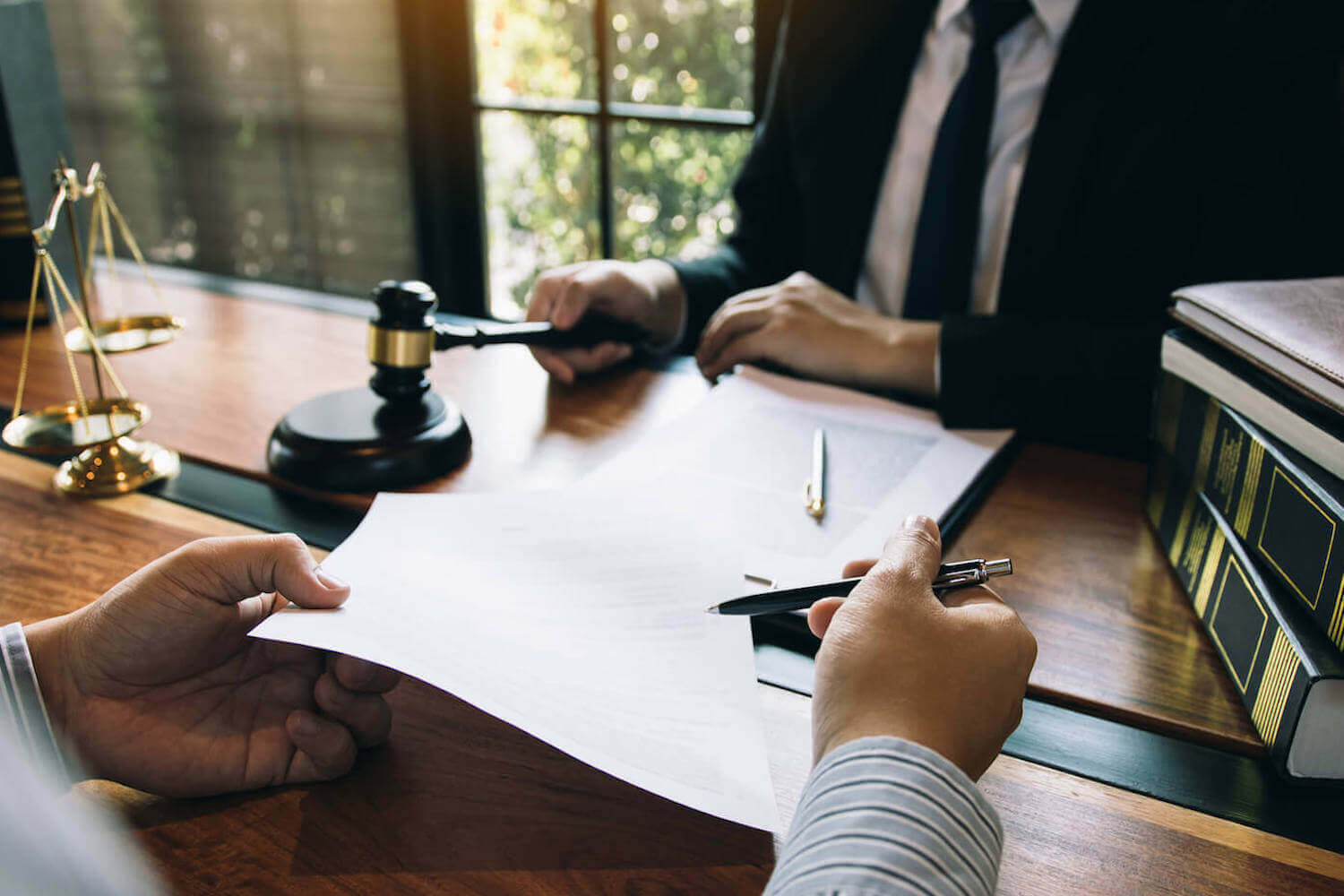Ein Unternehmer überprüft mithilfe eines Anwalts die rechtliche Grundlage einer virtuellen Hauptversammlung und zeigt ihm wichtige Dokumente.