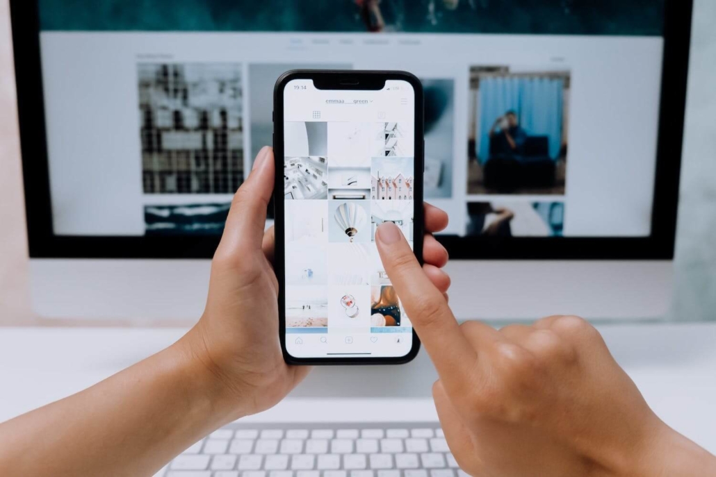 Eine Frau hält ein Handy und zeigt darauf einen Instagram Feed für junge Zielgruppen