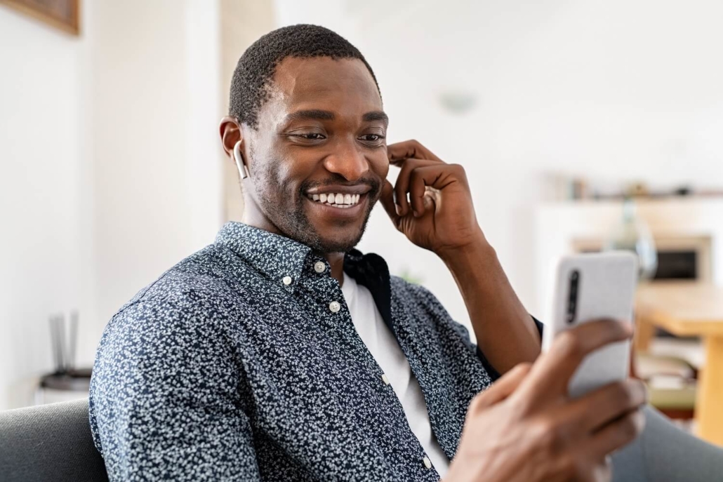 Lächelnder Mann mit Smartphone wird während eines Live Commerce Events hinzugeschaltet.