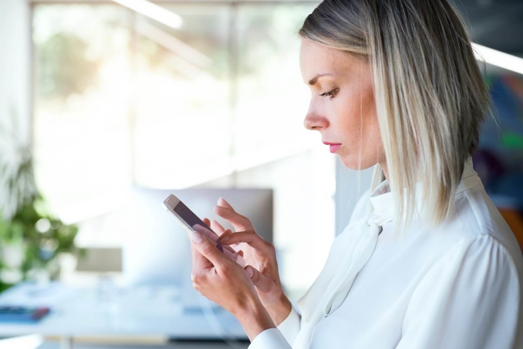 Eine Frau swipet auf Ihrem Smartphone zum nächsten Kurzvideo.