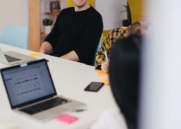 Mann im Büro lacht mit seinen Kollegen
