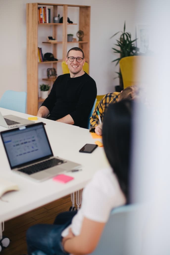 Mann im Büro lacht mit seinen Kollegen