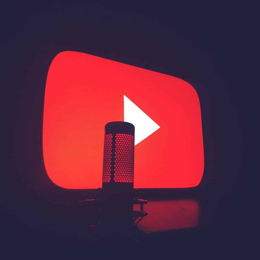 Ein Mikrofon vor einem leuchtenden YouTube-Logo.