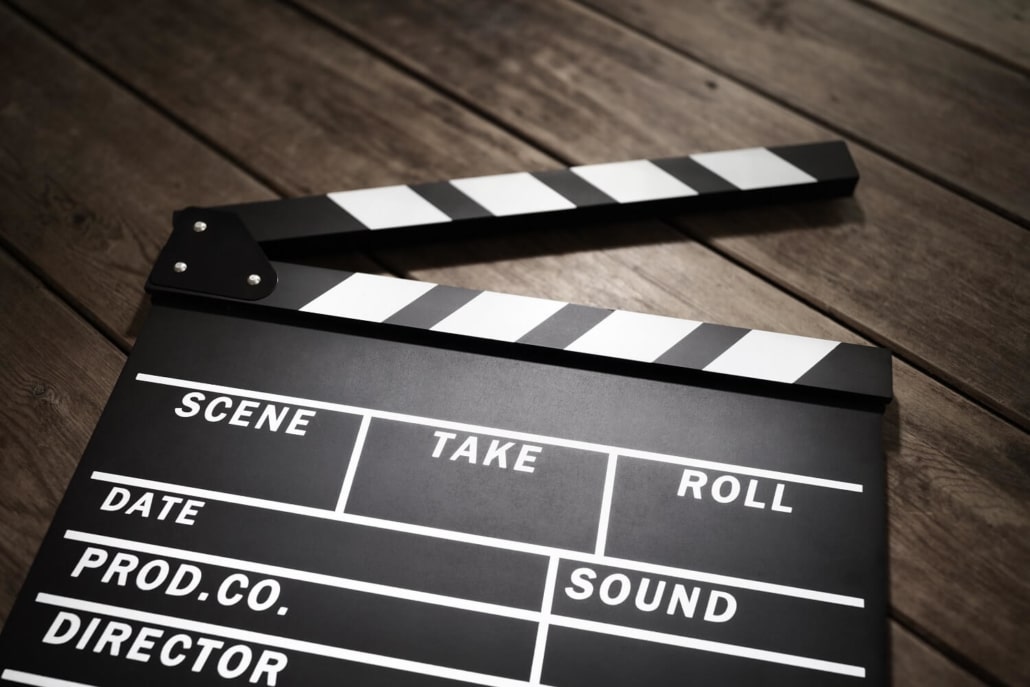 Eine Filmklappe auf dunkelbraunen Brettern.