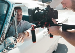 Ein Mann erstellt einen Werbespot, während er einen anderen Mann im Auto filmt.