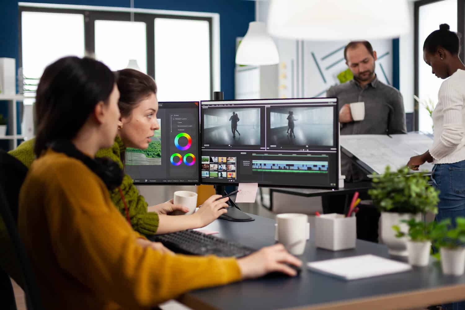 Eine Frau sitzt vor einem Computer und übersetzt gemeinsam mit einer Kollegin ein Video.