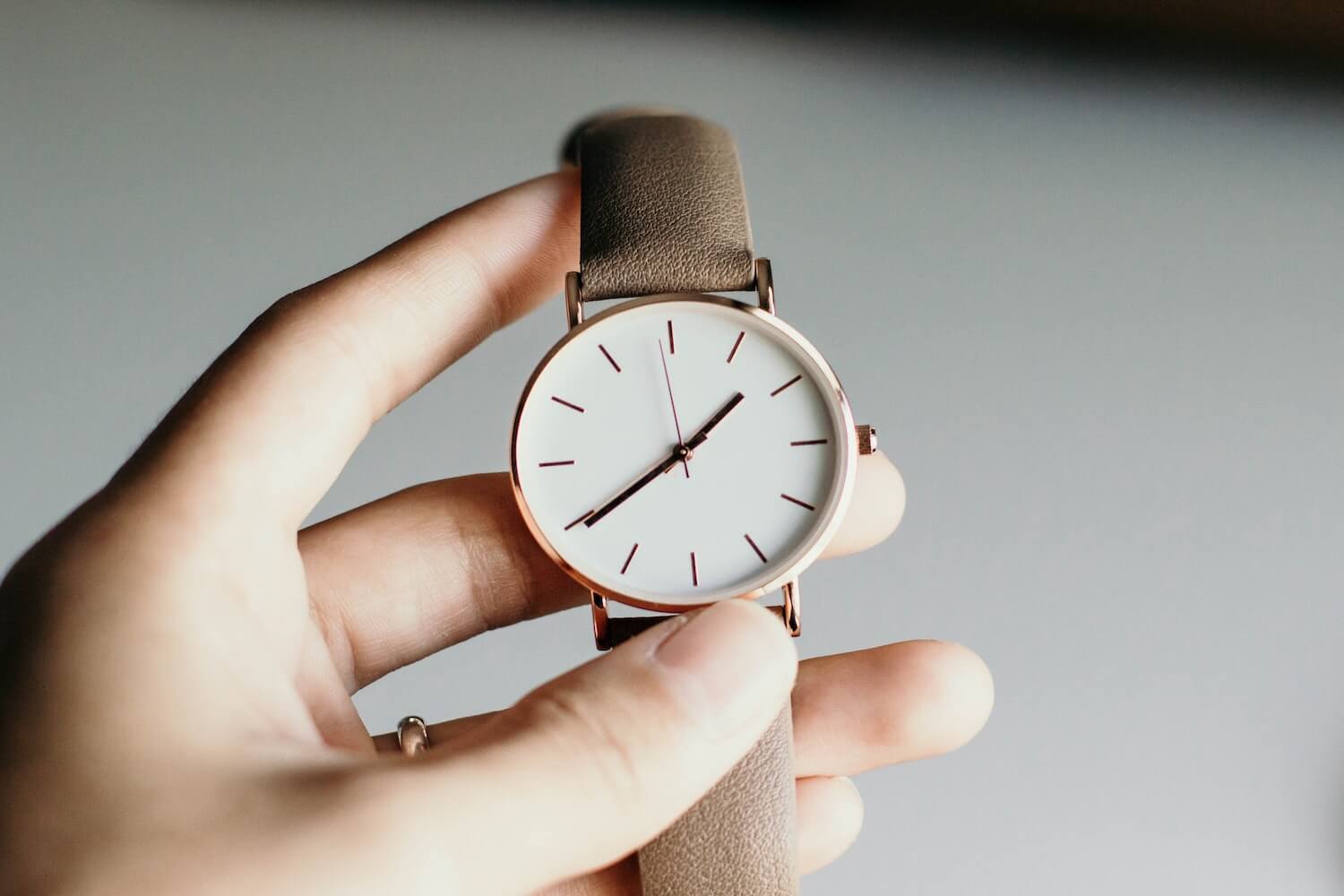Eine Frau hält eine Uhr in der Hand und kontrolliert die Zeit eines Livestreams.