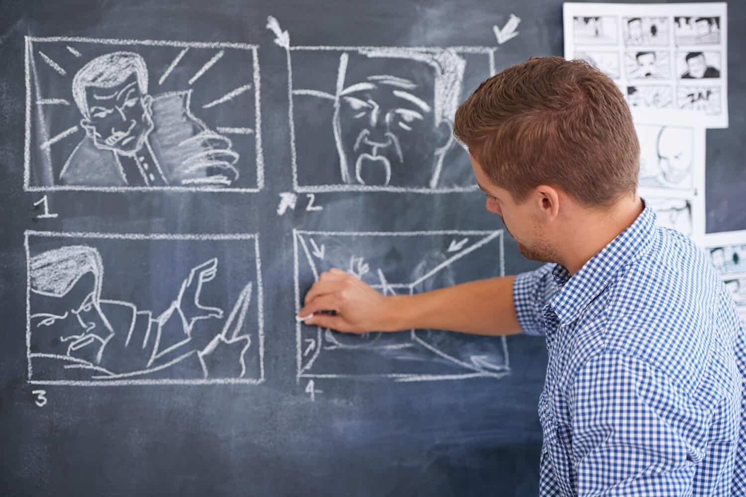 Ein Mann steht vor einer Tafel und plant ein Storyboard.