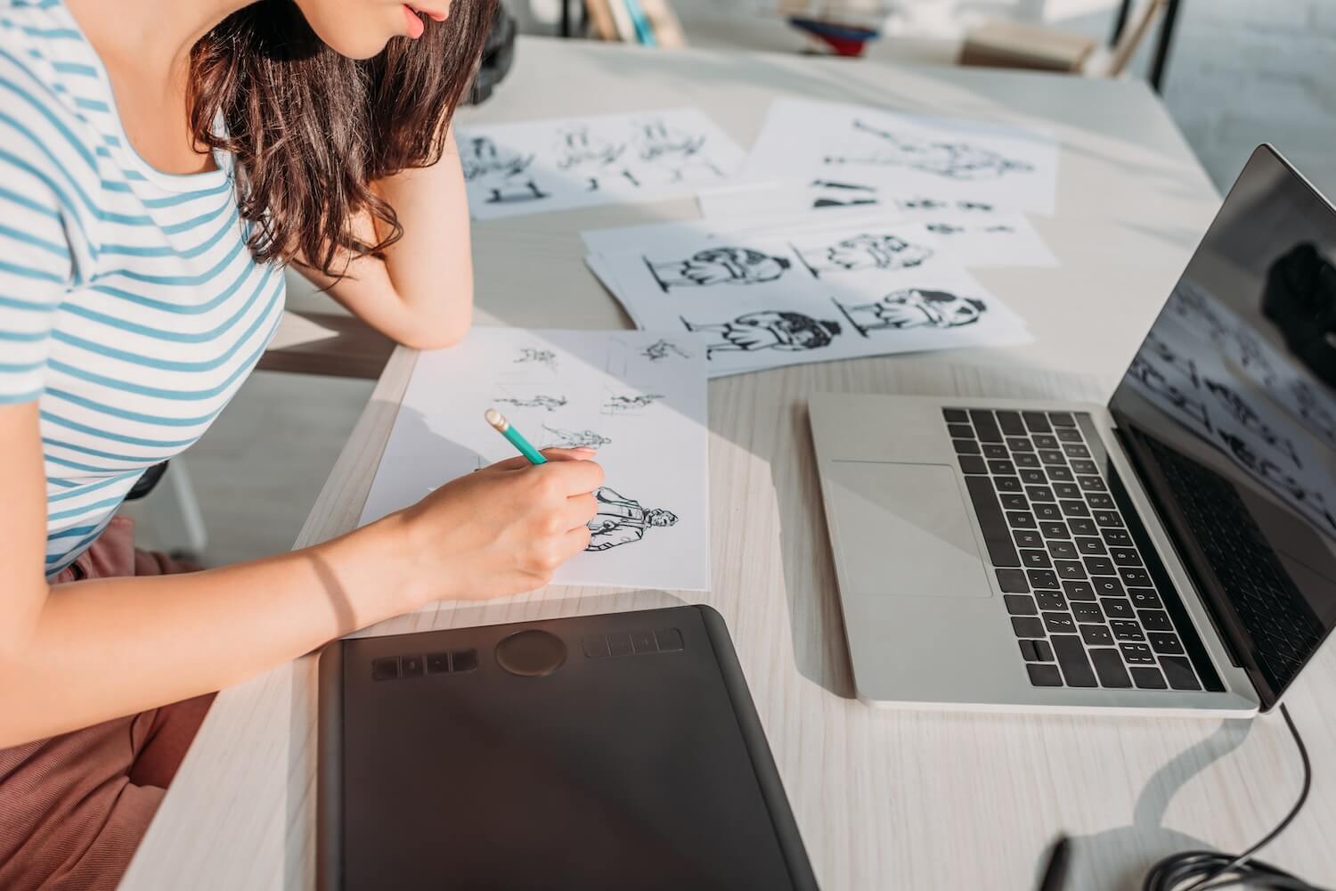 Eine Frau sitzt an ihrem Schreibtisch und arbeitet an einem Storyboard.